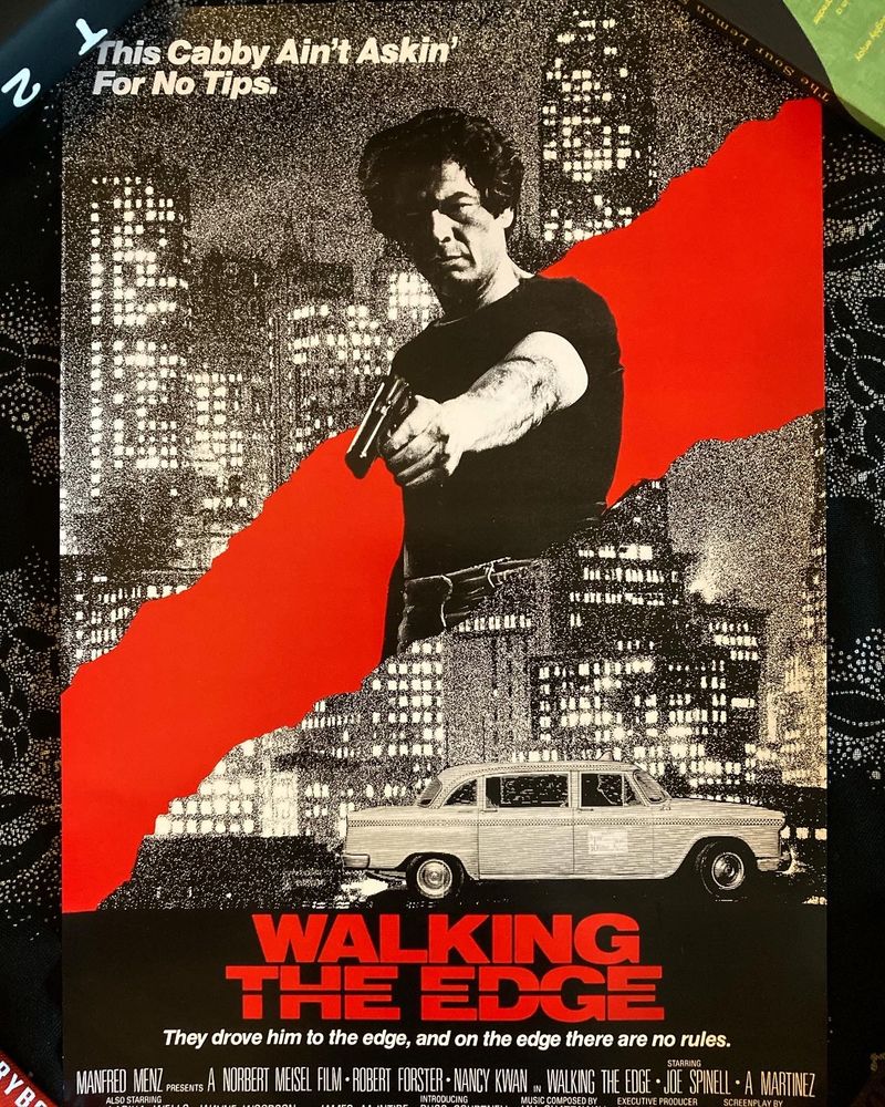 Walking the Edge poster - almost entirely black and white, with Robert Forster at the center, aiming a gun, with skyscrapers/a cityscape + taxi cab in the background and a thick diagonal slash of red behind him. at the top it reads "This Cabby Ain't Askin' For No Tips" in white letters. at the bottom it reads WALKING THE EDGE in red on a black background. underneath that, in smaller white font, it reads "They drove him to the edge, and on the edge there are no rules."  
