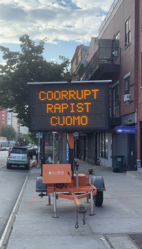 An electronic road sign reading “COORRUPT RAPIST CUOMO” (sic)