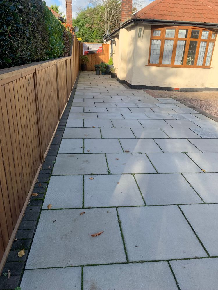 A long paved driveway with a lonely lest we forget flag at the end.
