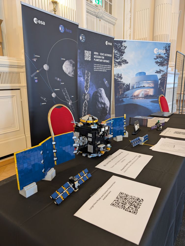 Photo of the ESA stand at the 2025 Asteroid Day Festival, featuring large posters and Lego models of ESA spacecraft