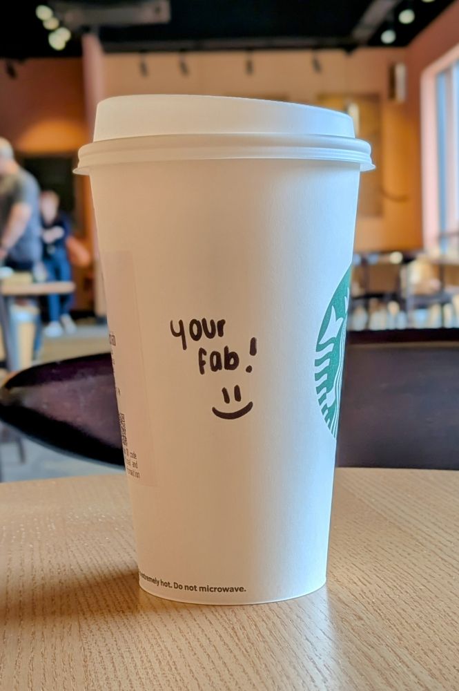 Starbucks coffee cup with 'Your fab!' written on it.