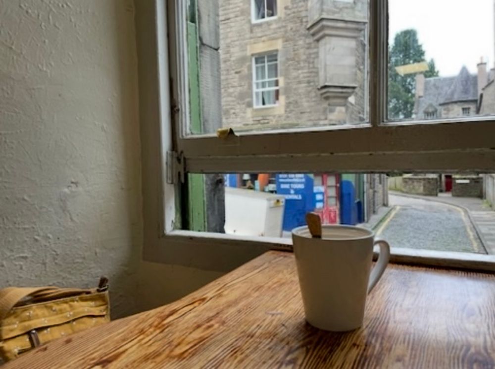 A table by a window with a coffee cup. 