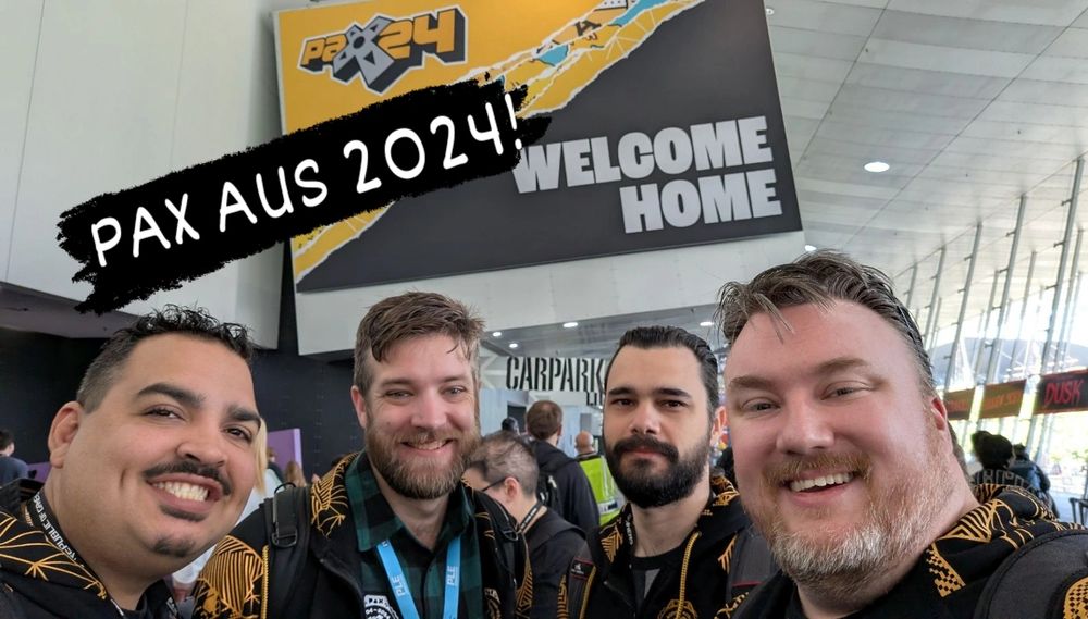 Four people standing in front of the PAXAUS 2024 welcome home sign