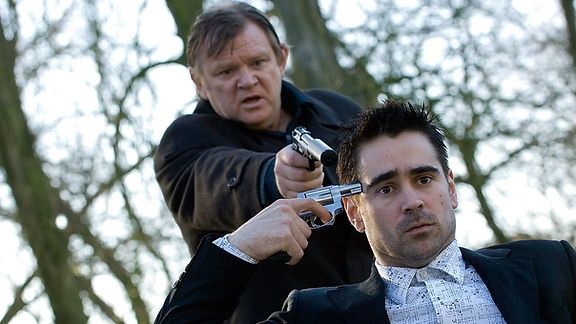 A screenshot from Martin McDonagh's film "In Bruges". The character of Brendan Gleeson is about to assassinate the character of Colin Farrell that is trying to suicide himself at the same moment 