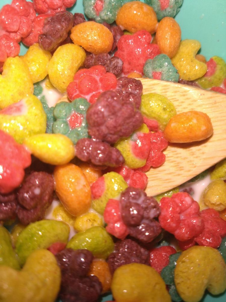 trix cereal with a wooden spoon and a teal plastic bowl
