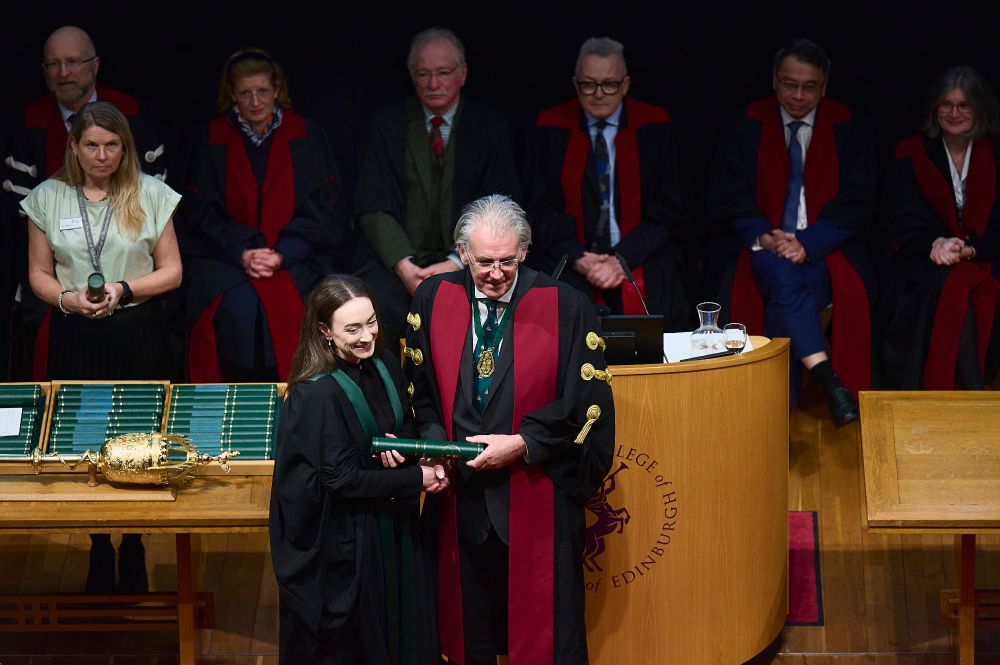 Person collecting their diploma from College President