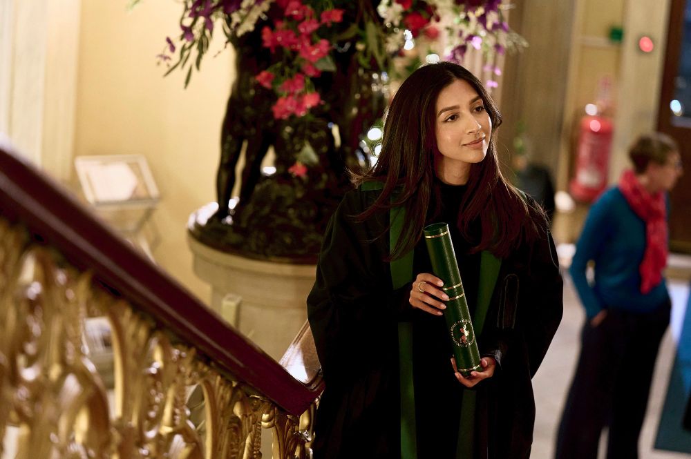 Person holding diploma on stairwell
