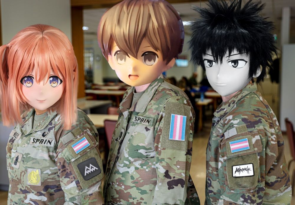 a picture of three female soldiers, originally from the US military, lining up in uniform for a picture. The "US army" mention have been replaced by the world "Spain", and their shoulder badges have been replaced by three transgender flags. The soldier on the left also has a Twin Peaks shoulder patch and the one on the right has an Avalanche (from Final Fantasy VII) shoulder patch. Finally, their faces have been altered to make it look like they're wearing kigurumi masks.