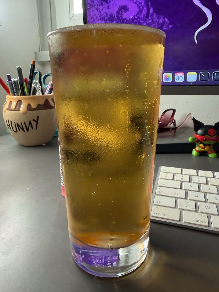 a glass full of beer to the brim on my office desk in front of my computer
