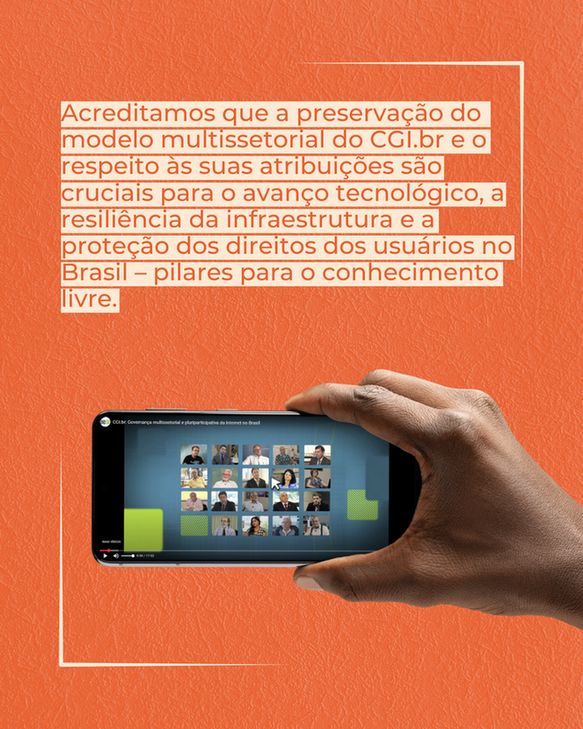 Fotografia em close-up de uma mão de uma pessoa, possivelmente de pele escura, segurando um smartphone na horizontal. A tela do celular exibe o que parece ser uma videoconferência com múltiplos participantes em pequenas janelas. A maior parte da imagem é coberta por um fundo laranja sólido com um texto extenso em letras brancas, contornado por uma fina linha branca. O texto diz: "Acreditamos que a preservação do modelo multissetorial do CGI.br e o respeito às suas atribuições são cruciais para o avanço tecnológico, a resiliência da infraestrutura e a proteção dos direitos dos usuários no Brasil – pilares para o conhecimento livre."