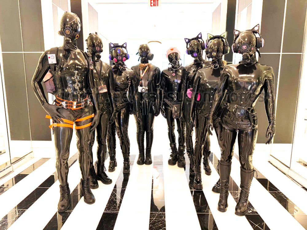 Latex Hexcorp drones, standing menacingly in a hallway.