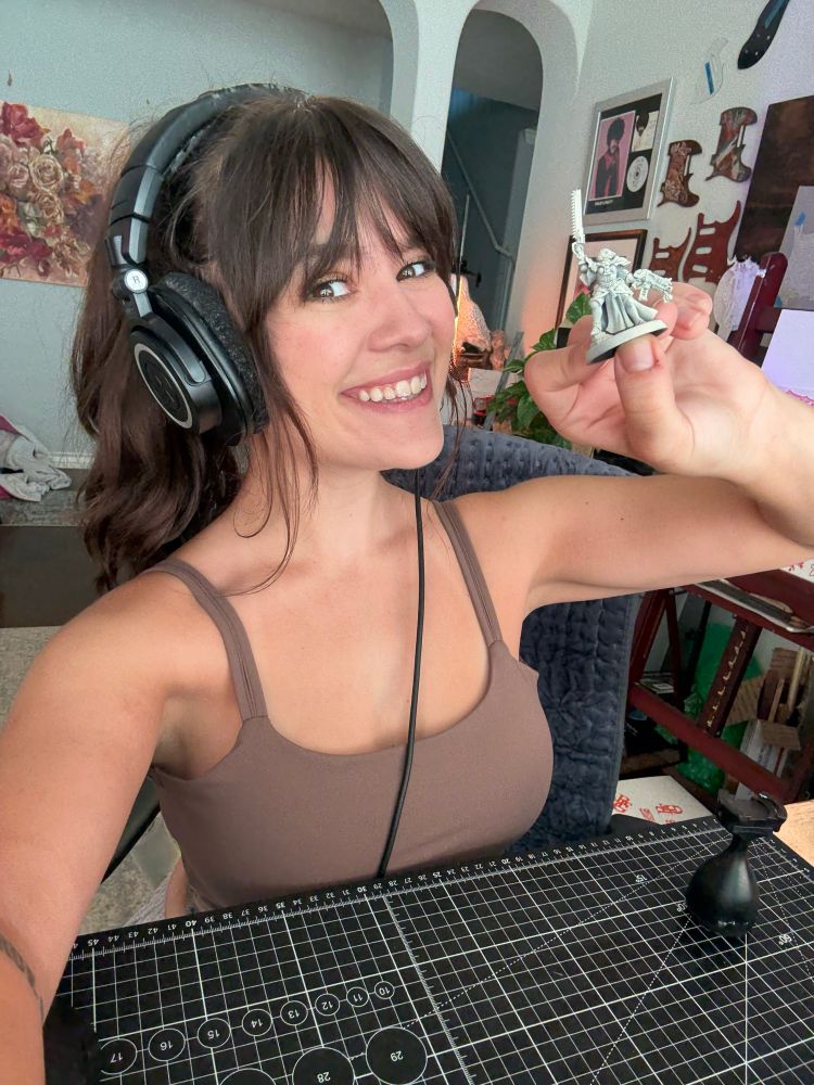 Selfie of me holding an unpainted grey sister of battle mini