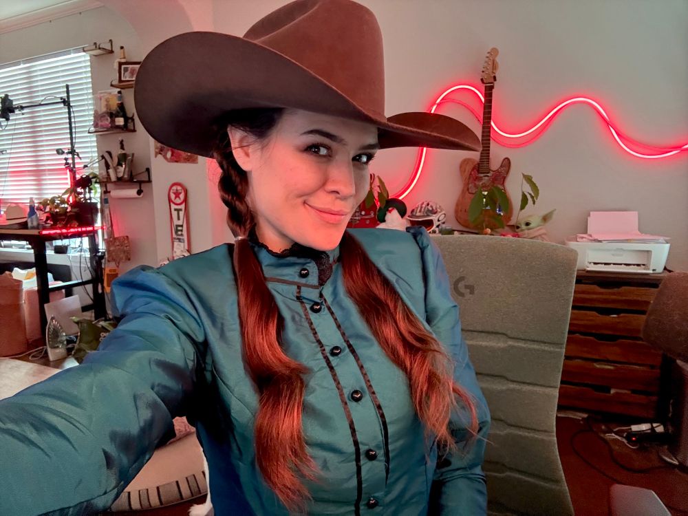 Selfie of me in an old fashioned dress and cowboy hat with twisted pigtails 