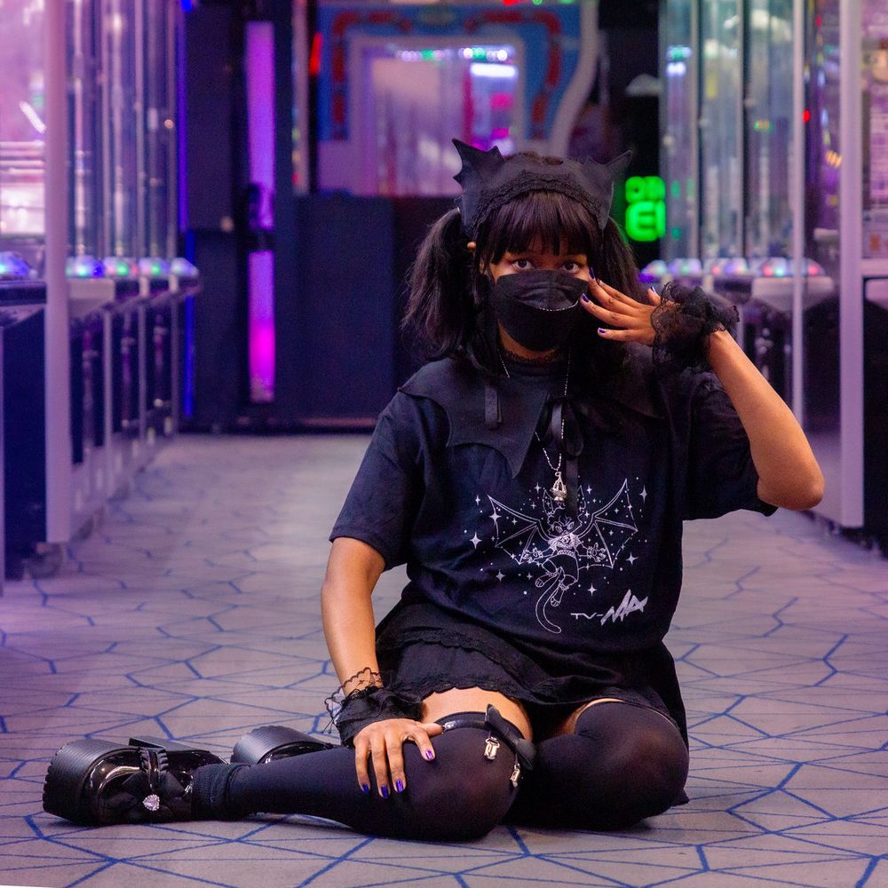 Photo of model (Lorraine) showing off TV-MA T-Shirt in brightly lit arcade