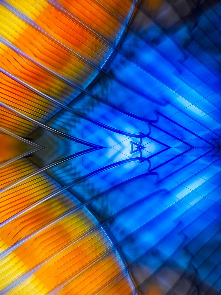 Abstract of a mobile sculpture with sharp, arrow-like lines and colorful patterns of yellow, orange, and blue.