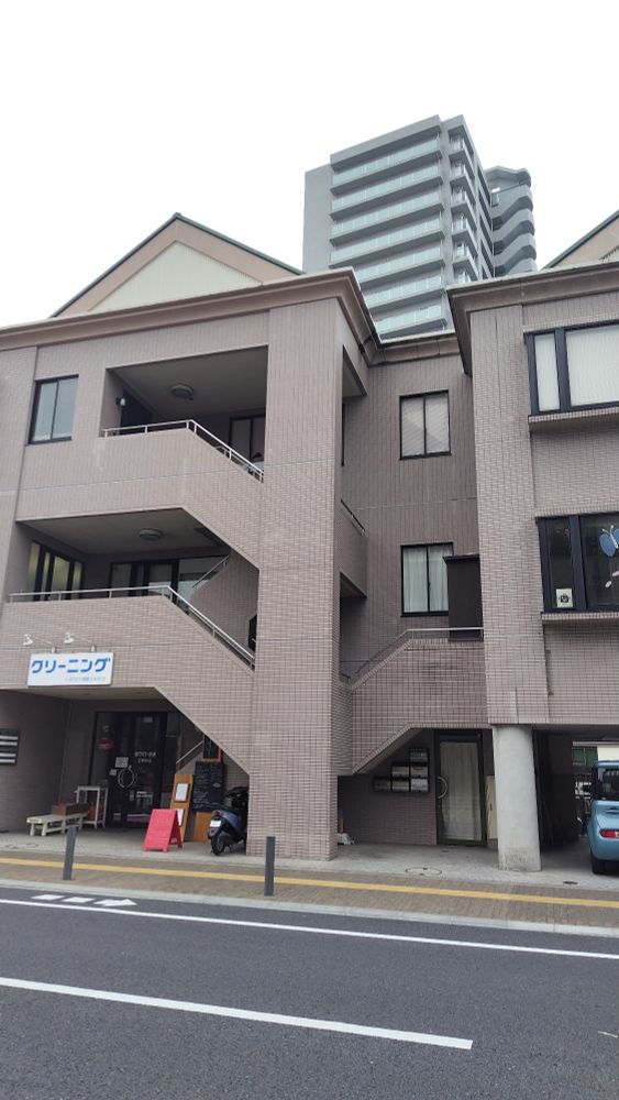 3階建て店舗つき住宅に円柱と三角屋根