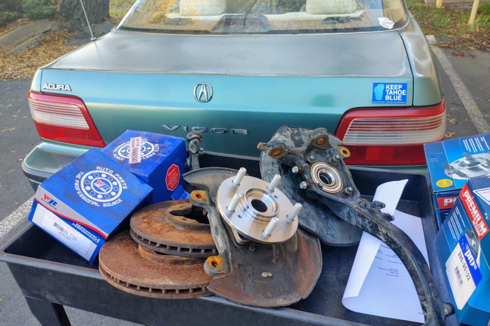 My 1994 Acura Vigor with a cart full of fresh and old parts behind the trunk