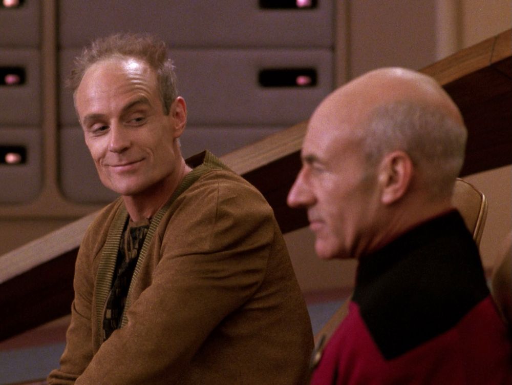 Professor Berlinghoff Rasmussen gives Captain Picard a shady sideways glance and a creepy smile, because he's a fucking scumbag. 