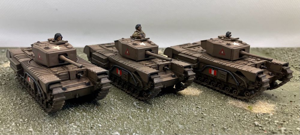 A photo of three model Churchill tanks.