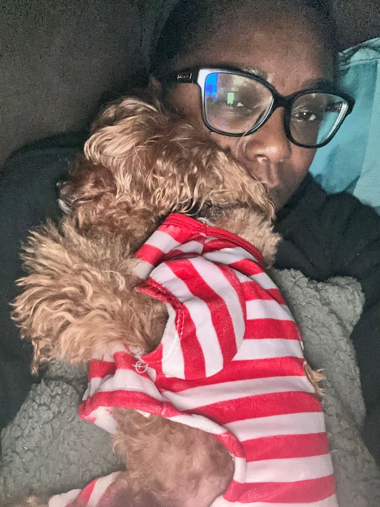 Puppy in stripped onesie sleeping on his human’s face.