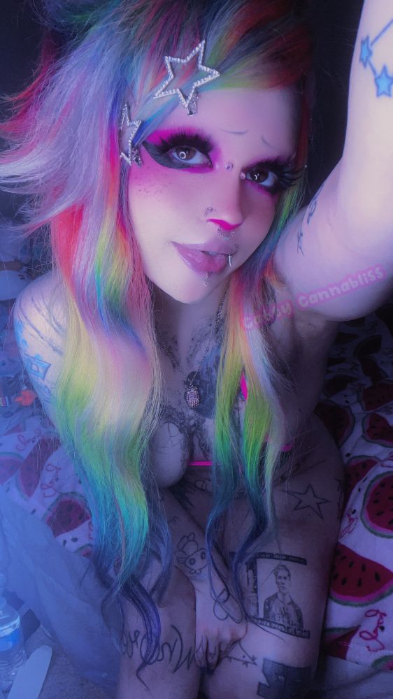 Catty taking a selfie from an upwards angle, sitting on the edge of her bed