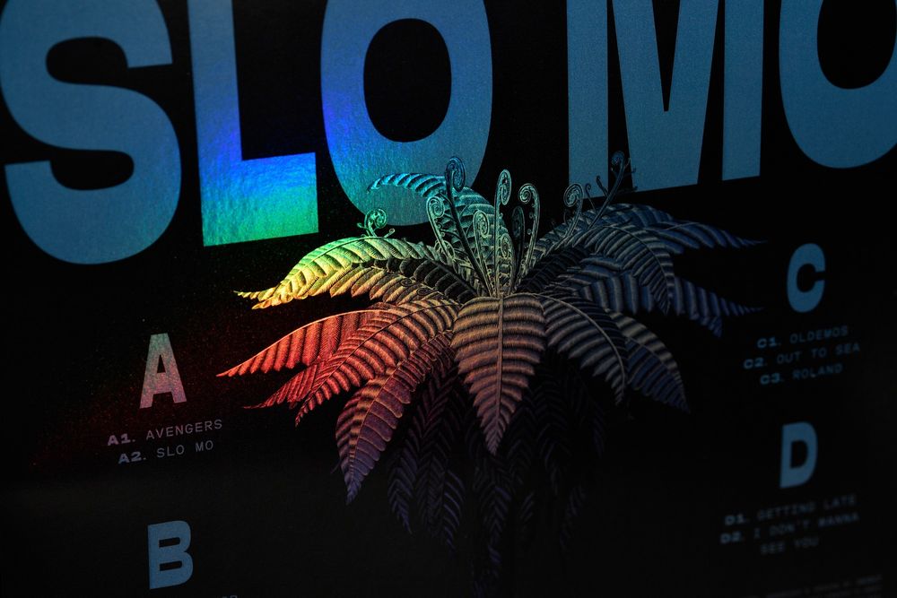 Close up SLO MO Deluxe vinyl album art, Fat Freddy's Drop new album, foil bling on ponga tree. 