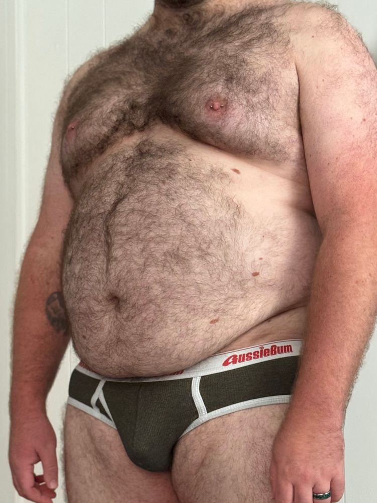 Cropped photo of my midsection. I’m wearing a pair of olive colored briefs with white trim. 