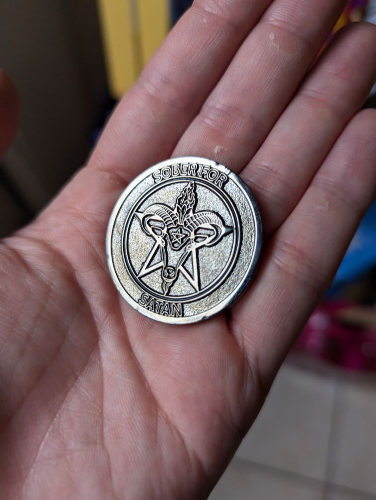 Picture of a coin that says "Sober for satan" in the centre it has a goats head in front of a pentagram, with ANOTHER pentagram in the goats forehead. I mean. Wowee. 