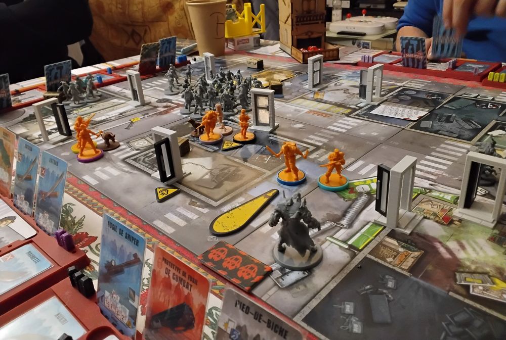 Later in the game, an Abomination just spawned 1 space away from 2 survivors.
A flashlight token shows that it’s nightime in game. 
Penny is safe inside the server room, we found 2 dog companions, but there’s a HUGE cluster of Zombies coming in our way... Will we survive ?!
Spoiler : Yes we did.
Onward to mission 3 o/