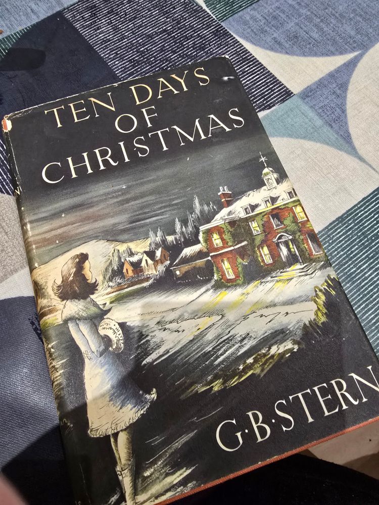 A hardback edition of Ten Days of Christmas. 1950 edition with dustjacket. A girl stands in a winter landscape looking toward a large country house.