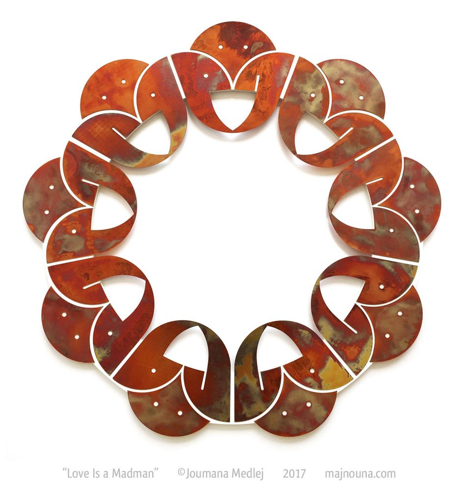 Word-based mandala in iridescent copper floating over the wall