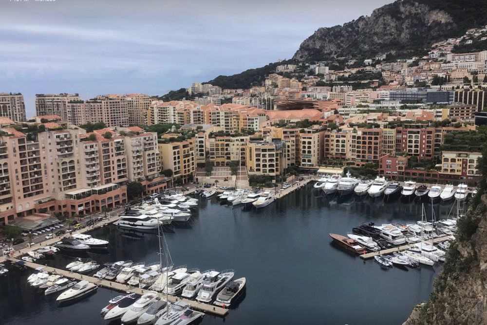 Looking down into the Monaco Yacht basin from Monaco City.  There are numerous yachts moored and in the background a large number of high rise buildings