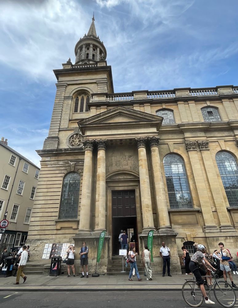 A grand stone church built in classical style with a massive portico, high windows, and a spire