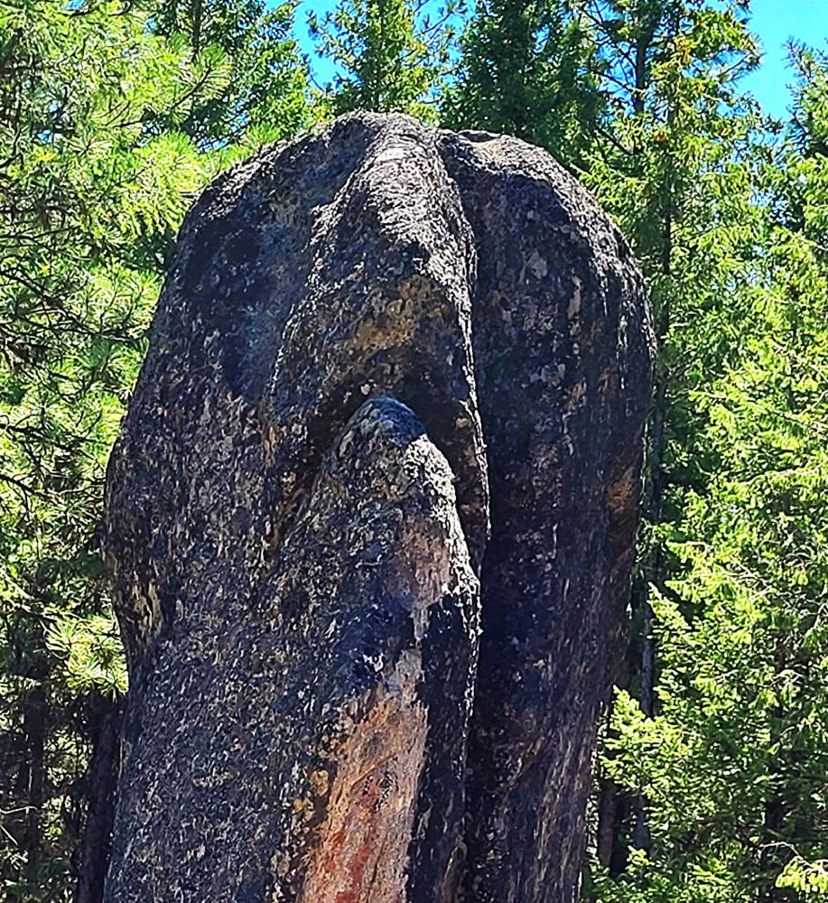 A closer view of the stone face. From this angle, the rock appears to have eyes, a nose, and a curved mouth.