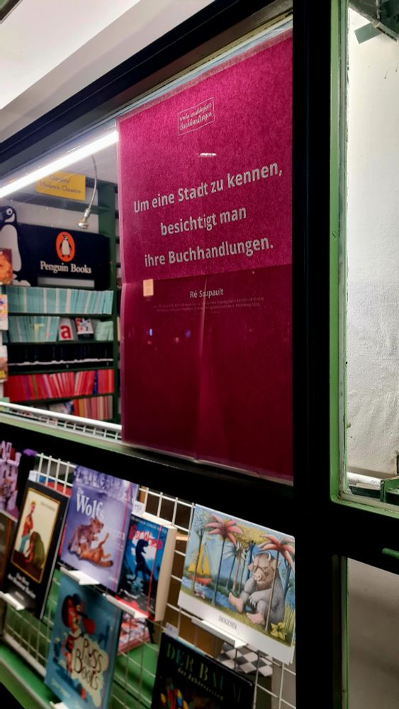 Blick in das Schaufenster der Buchhandlung von der dunklen Straße aus. Der Laden ist geschlossen.