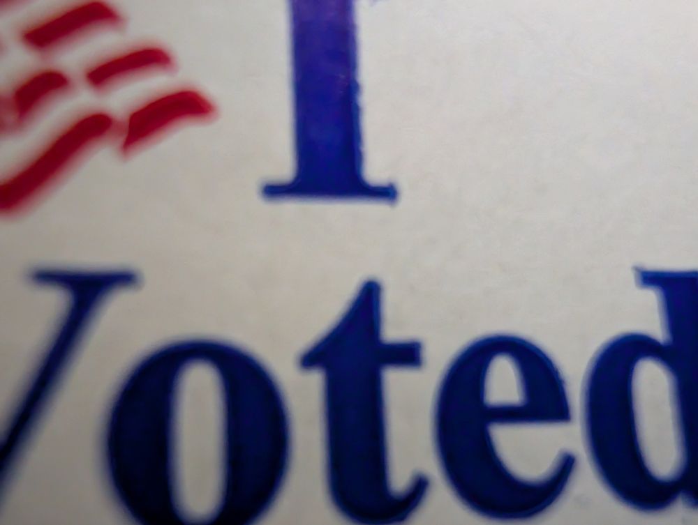 An overly zoomed-in photo of an "I voted" sticker