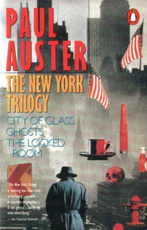 The book cover of Paul Auster's anthology _The New York Trilogy_ has text in red, yellow, blue, and white that includes the names of the three novels contained in the anthology: _City of Glass_, _Ghosts_, and _The Locked Room_.  This text is superimposed over a collage of images including the New York City skyline, a fire hydrant, a coffee cup, a skull, several American flags, and other objets.