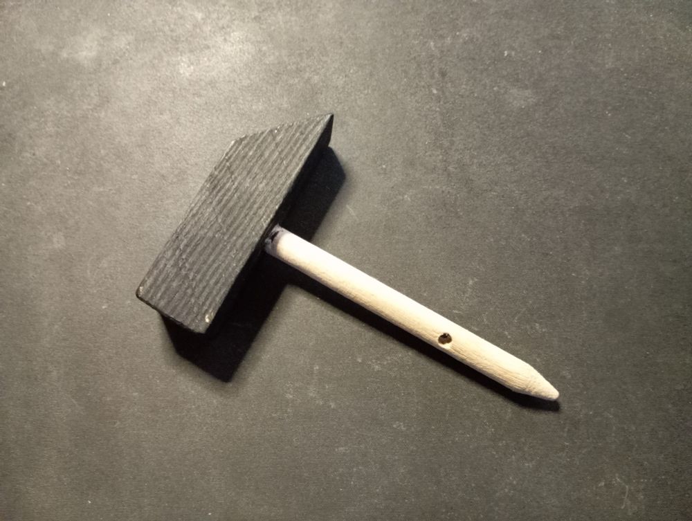 Ein kleiner, aus Holz gebastelter Hammer.