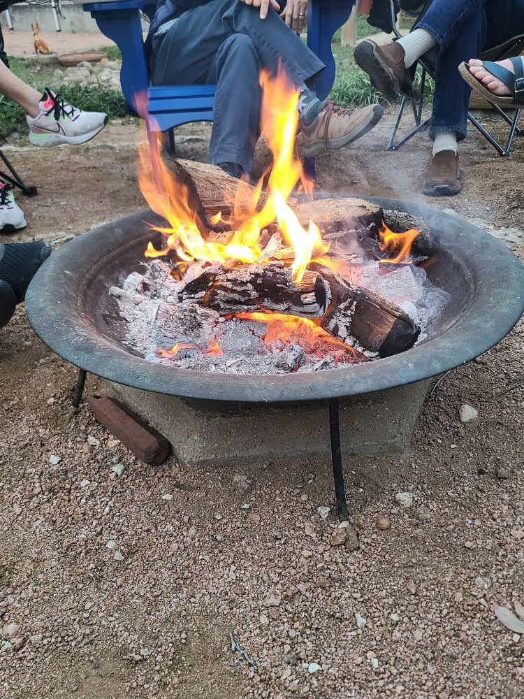 Picture of a fire surrounded by people chatting.