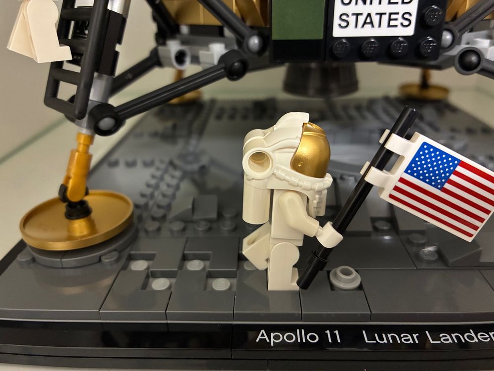 Astronauta de lego con una bandera de EEUU andando sobre la superficie lunar