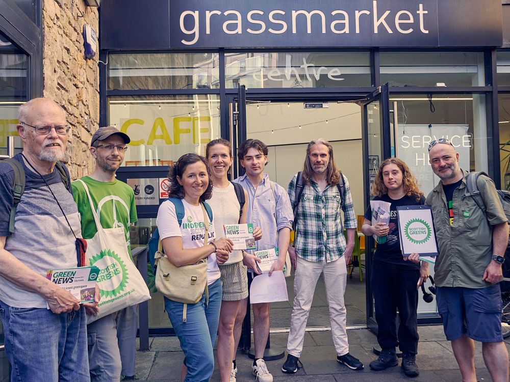 8 Central Edinburgh Green activists in front of the Grassmarket Community Project. They are looking happy to have gotten their hands on the latest edition of their local Green News.