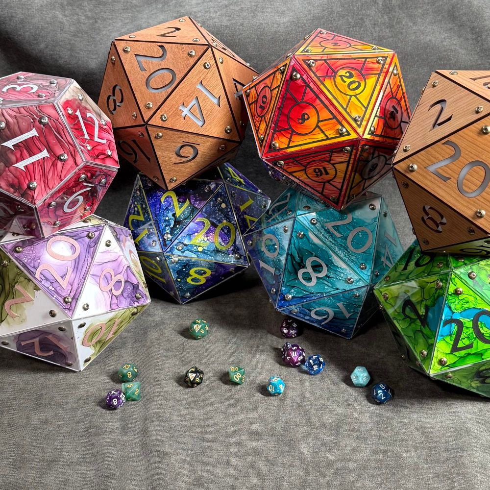 8 giant dice made of wood or brightly painted acrylic on a gray backdrop with normal sized dice on it. 