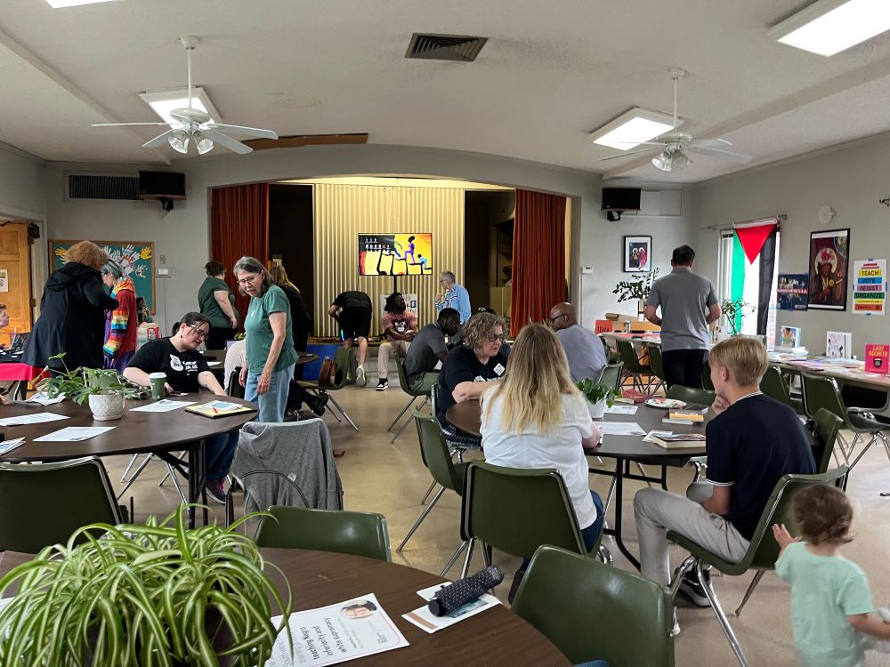 Group of people gathering in a room for Teach Truth day of action 
