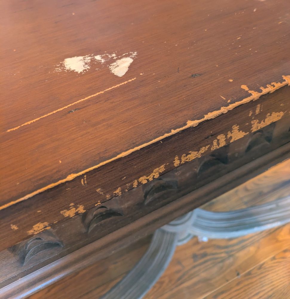 photo of a wooden table top that shows chips and scratches