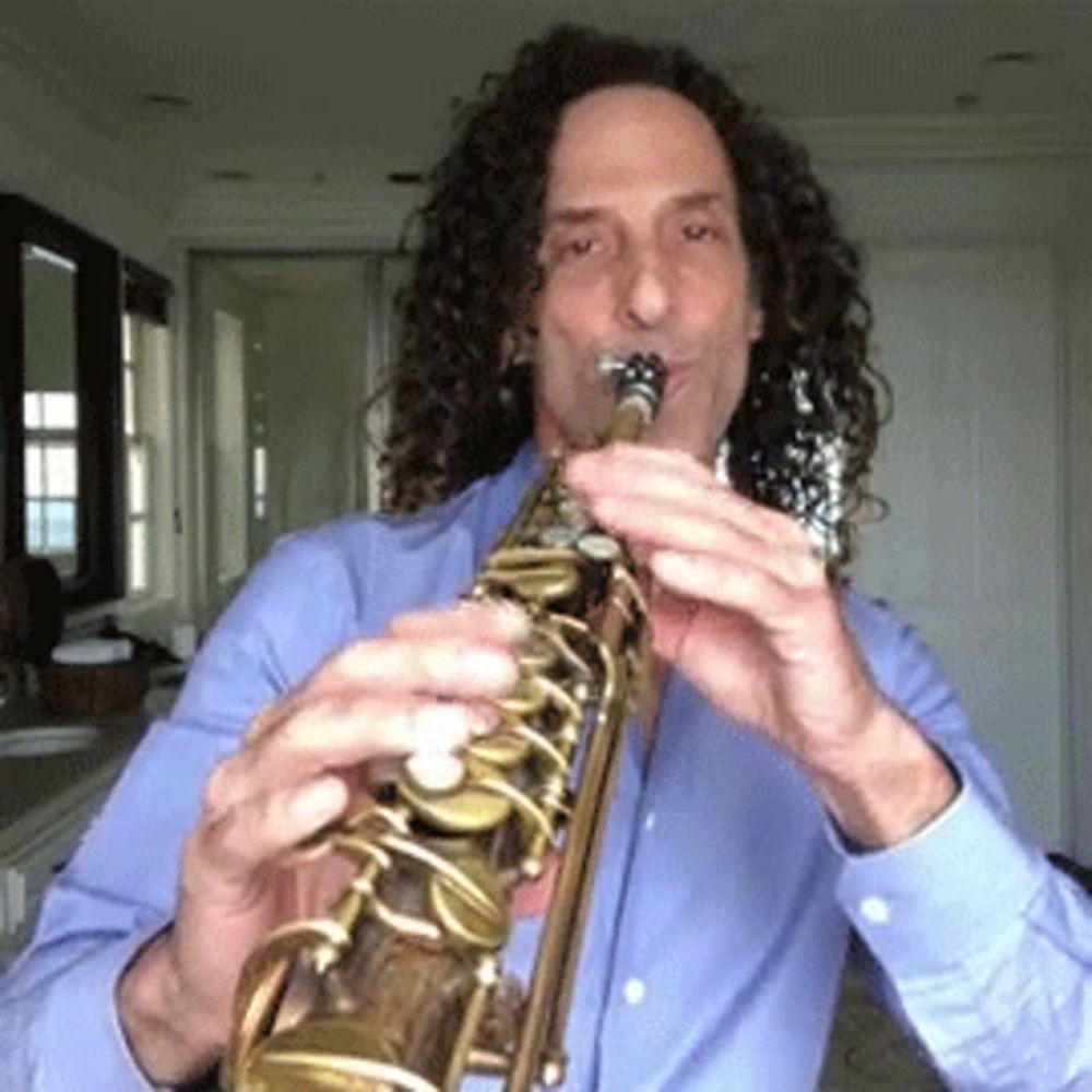 a man with curly hair is playing a saxophone in a room