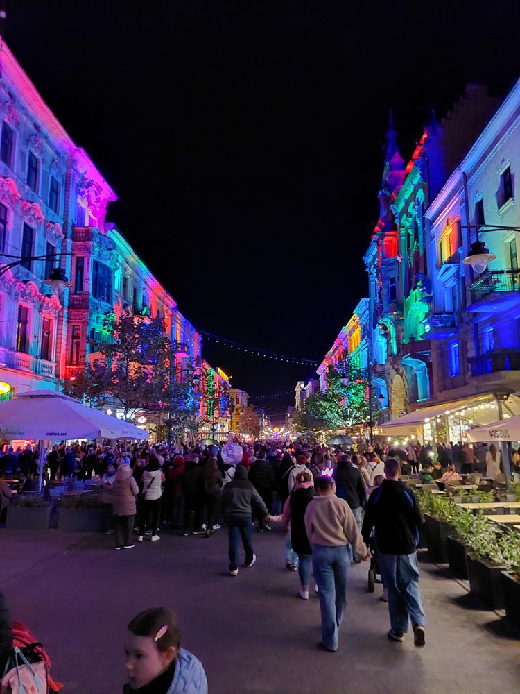 View of street with people, buildings colorfully lit