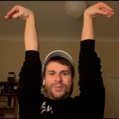 Nathan foad holding his arms straight up with wrists bent like he's some sort of 2 headed swan