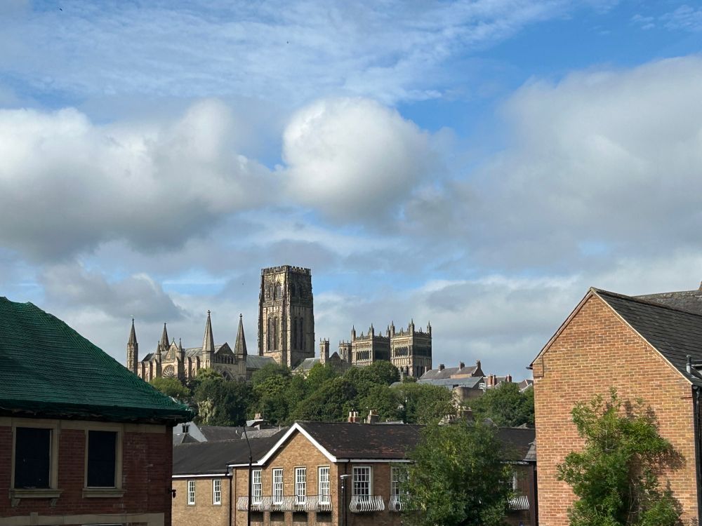 A view of the gothic towers of Durham Cathedral through a gap in some houses