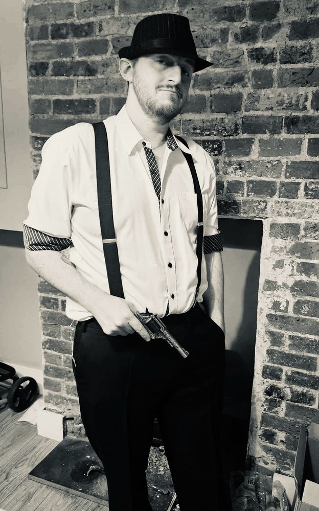 Black and white picture of me dressed in a shirt, suspenders and trilby