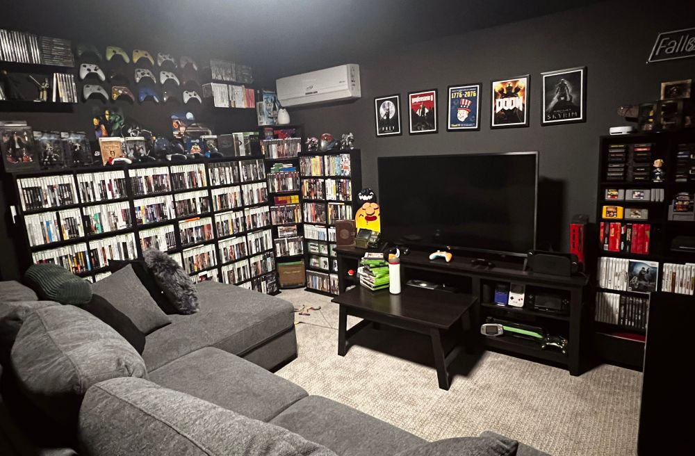 Mo’s gaming room filled with various consoles, physical game discs, and merch.